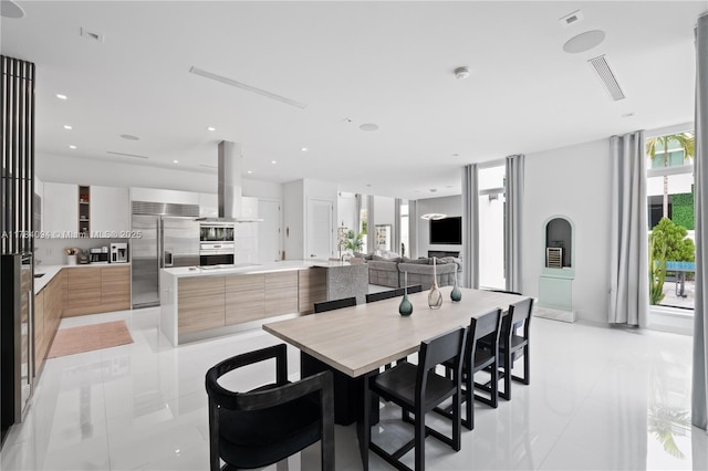 dining space featuring light tile patterned flooring and visible vents