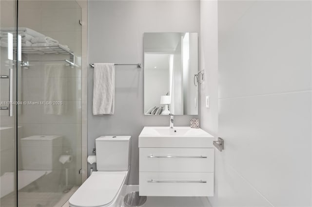 bathroom featuring a shower stall, toilet, and vanity