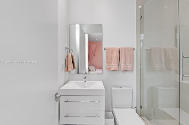 bathroom with a shower stall, toilet, and vanity