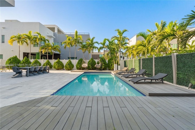 view of swimming pool with fence, a wooden deck, and a fenced in pool