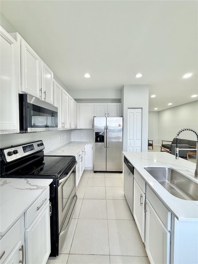 1047 NW 33rd Mnr, Pompano Beach, FL 33064 - kitchen featuring appliances with stainless steel finishes, a sink, white cabinetry, light tile patterned flooring, and light stone countertops