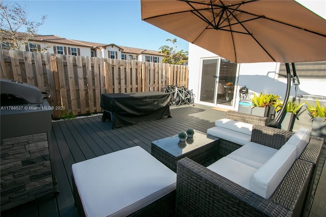 wooden deck with fence, an outdoor living space, a grill, and a residential view