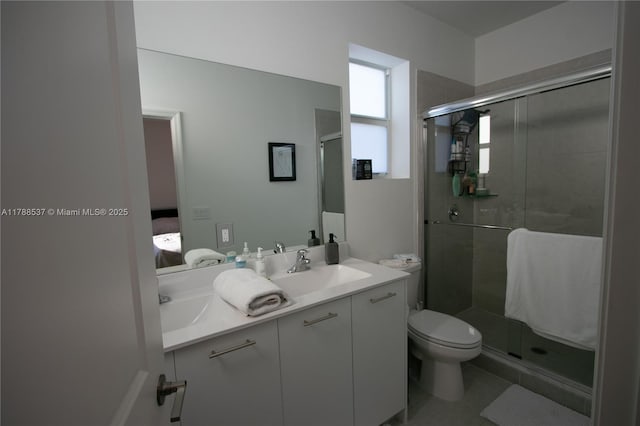 bathroom with a shower stall, toilet, vanity, and ensuite bathroom