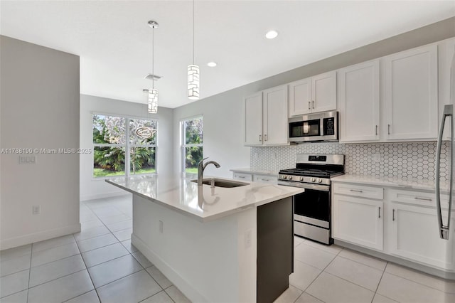 kitchen featuring appliances with stainless steel finishes, a sink, decorative backsplash, white cabinetry, and recessed lighting
