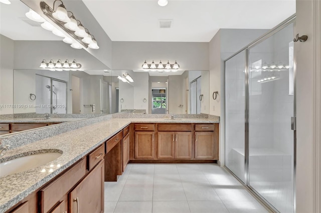 full bath with a shower stall, tile patterned floors, and double vanity