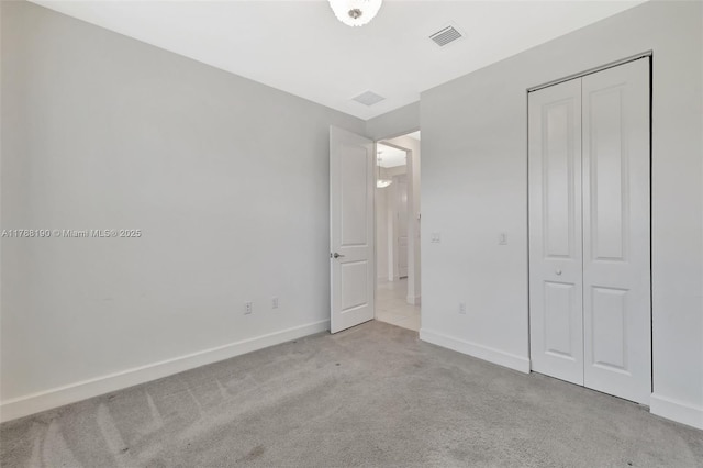 unfurnished bedroom with carpet floors, baseboards, and a closet