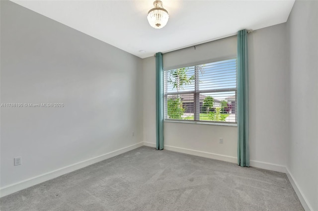 carpeted empty room with baseboards