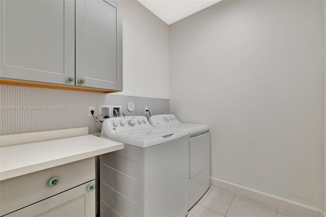 laundry room with cabinet space, washer and clothes dryer, light tile patterned flooring, and baseboards