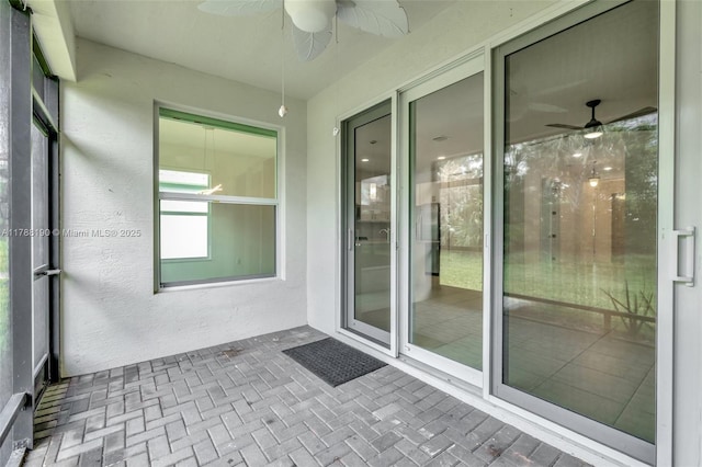unfurnished sunroom featuring a ceiling fan