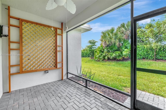 unfurnished sunroom featuring ceiling fan