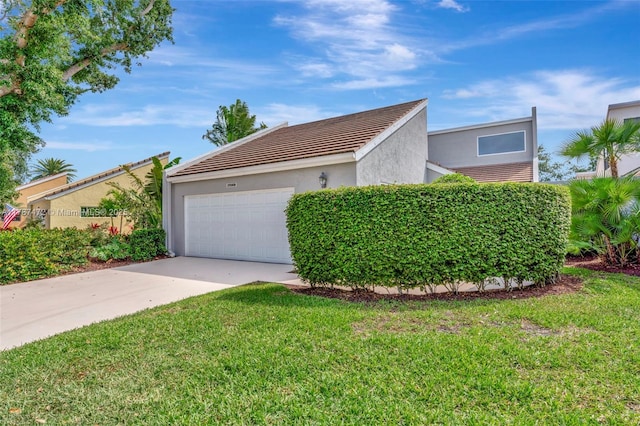 17068 Traverse Cir, Jupiter, FL 33477 - view of side of property with concrete driveway, stucco siding, a garage, a yard, and a tiled roof