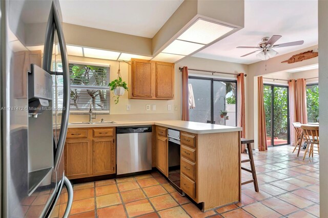 17068 Traverse Cir, Jupiter, FL 33477 - kitchen with stainless steel appliances, a peninsula, a sink, ceiling fan, and light countertops