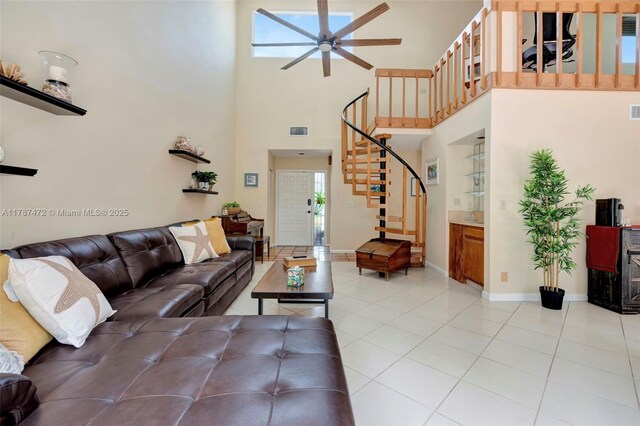 17068 Traverse Cir, Jupiter, FL 33477 - living area with stairs, a ceiling fan, light tile patterned floors, a towering ceiling, and baseboards