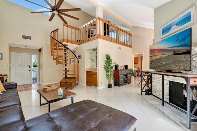 17068 Traverse Cir, Jupiter, FL 33477 - living room featuring ceiling fan, stairs, light tile patterned floors, a towering ceiling, and baseboards