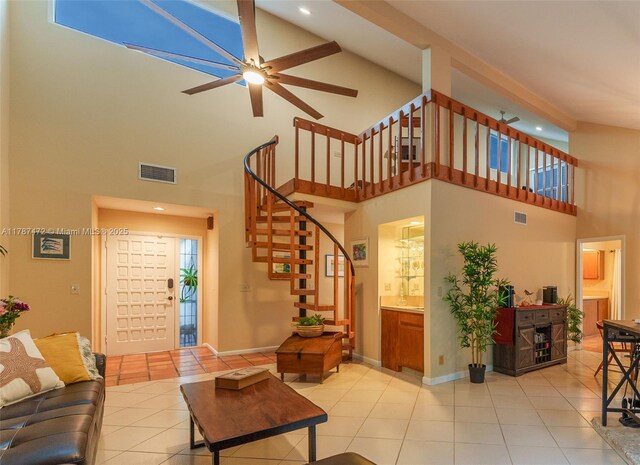 17068 Traverse Cir, Jupiter, FL 33477 - living area featuring a towering ceiling, light tile patterned floors, stairway, ceiling fan, and baseboards