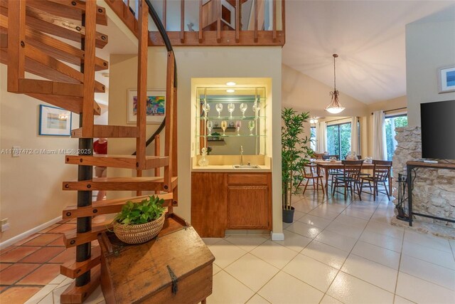 17068 Traverse Cir, Jupiter, FL 33477 - interior space with high vaulted ceiling, light tile patterned floors, baseboards, decorative light fixtures, and stairs