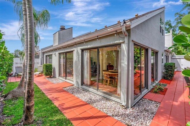 17068 Traverse Cir, Jupiter, FL 33477 - back of house featuring stucco siding and a chimney