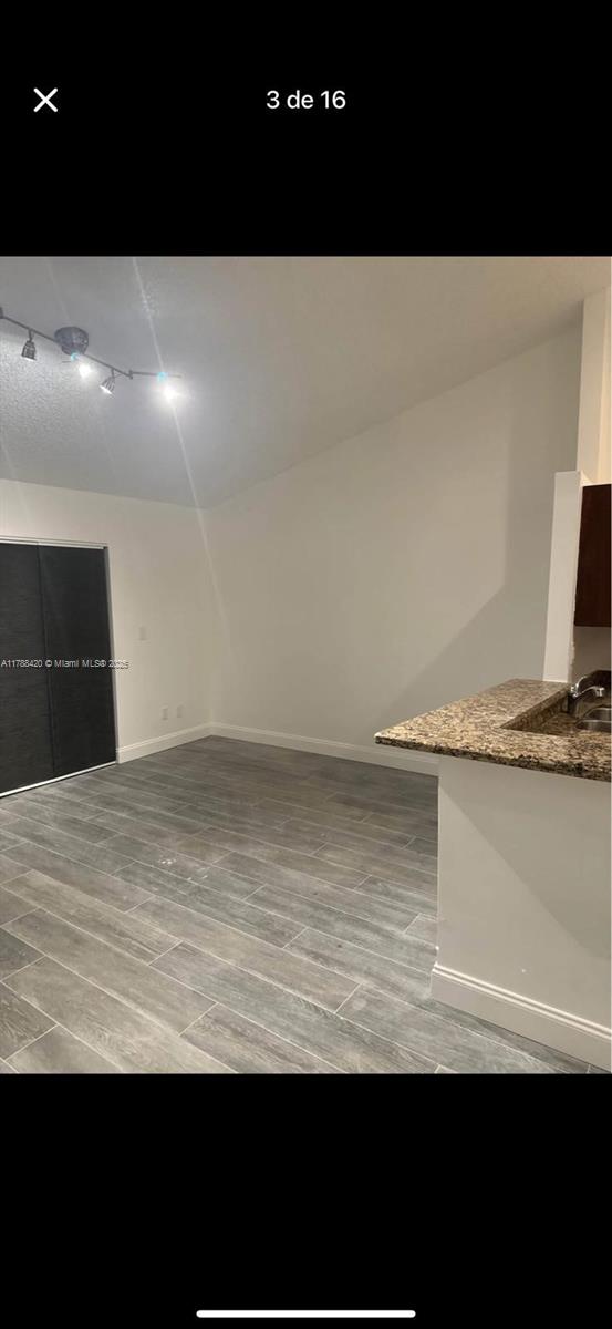 interior space with track lighting, light wood-style flooring, and baseboards