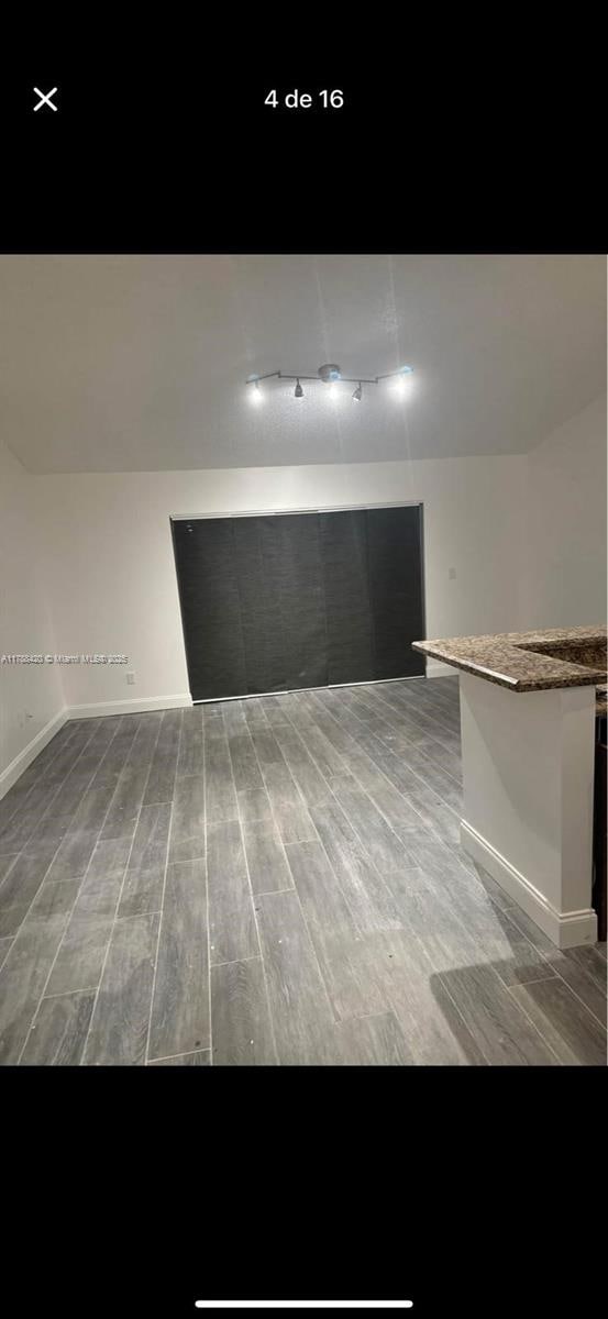 interior space with track lighting and wood finished floors
