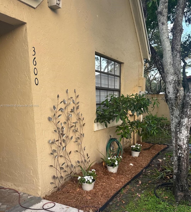 doorway to property with fence and stucco siding