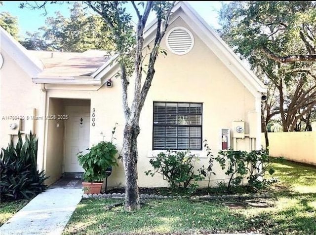 exterior space featuring stucco siding and fence