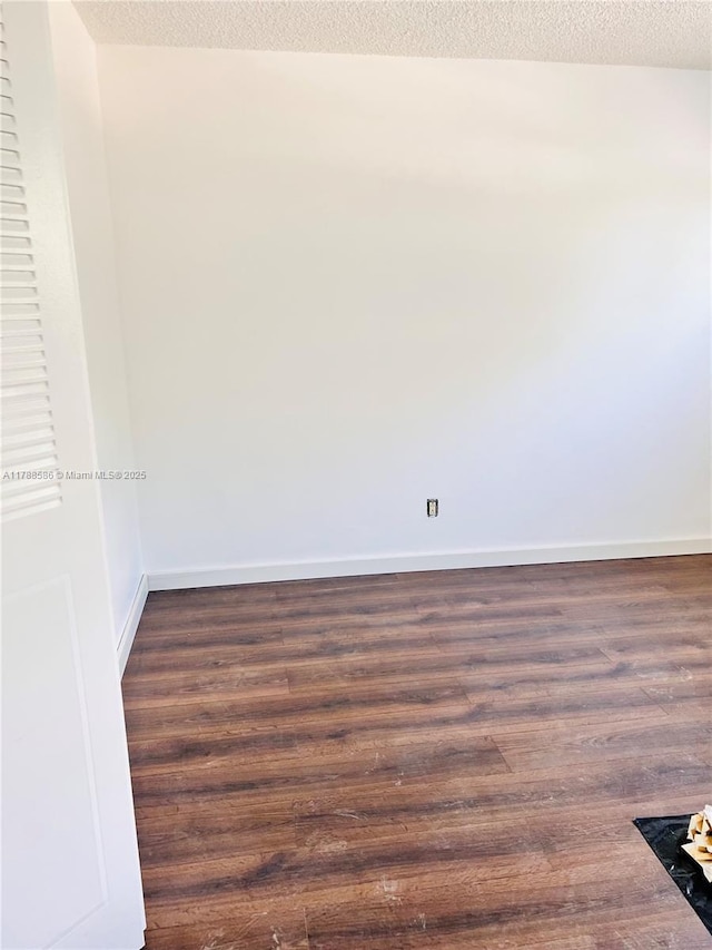 6191 SW 37th St Unit 106, Davie, FL 33314 - unfurnished room featuring dark wood-style flooring, baseboards, and a textured ceiling