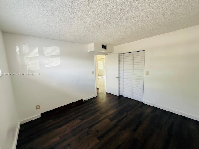 6191 SW 37th St Unit 106, Davie, FL 33314 - unfurnished bedroom with a closet, a textured ceiling, dark wood-style flooring, and baseboards