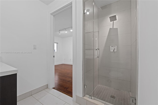 full bath featuring a shower stall, baseboards, and tile patterned flooring