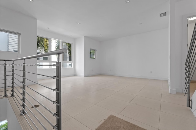 interior space featuring baseboards, visible vents, and light tile patterned flooring