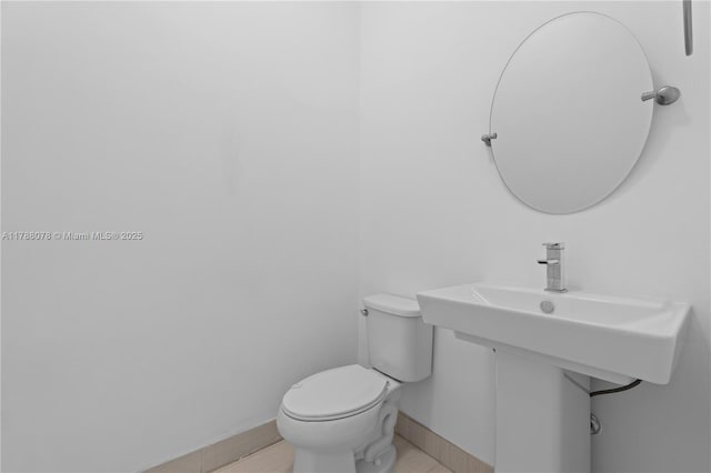 half bath with toilet and baseboards