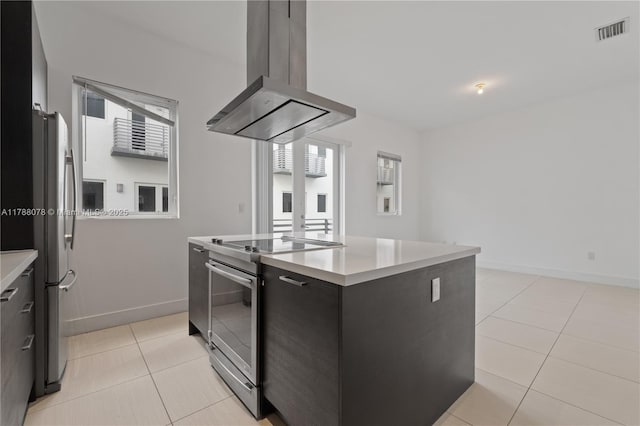 kitchen with island exhaust hood, light countertops, visible vents, a center island, and appliances with stainless steel finishes
