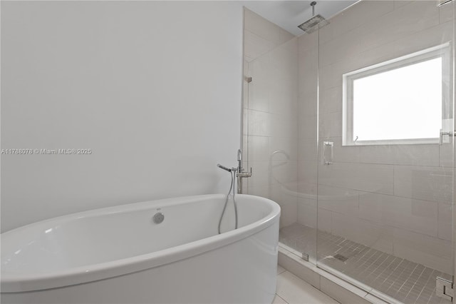 full bath with a freestanding bath, a shower stall, and tile patterned floors