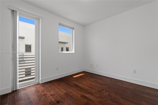 empty room with baseboards, dark wood-style flooring, and a healthy amount of sunlight