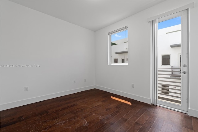 unfurnished room with dark wood finished floors and baseboards