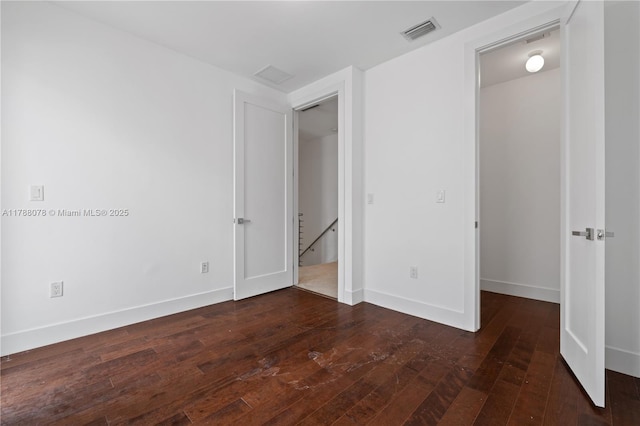 unfurnished bedroom featuring baseboards, visible vents, and wood-type flooring