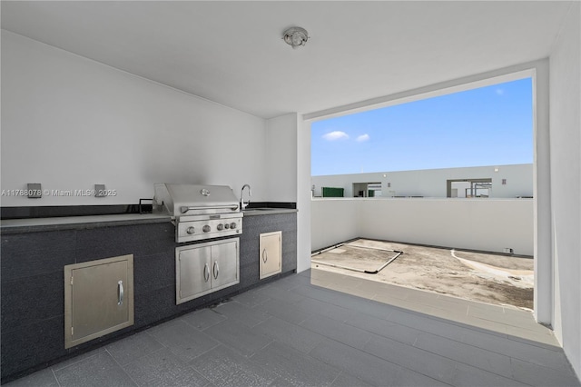 view of patio with exterior kitchen, a sink, and area for grilling