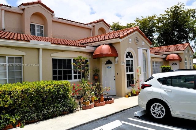 view of front of property featuring stucco siding and a tiled roof