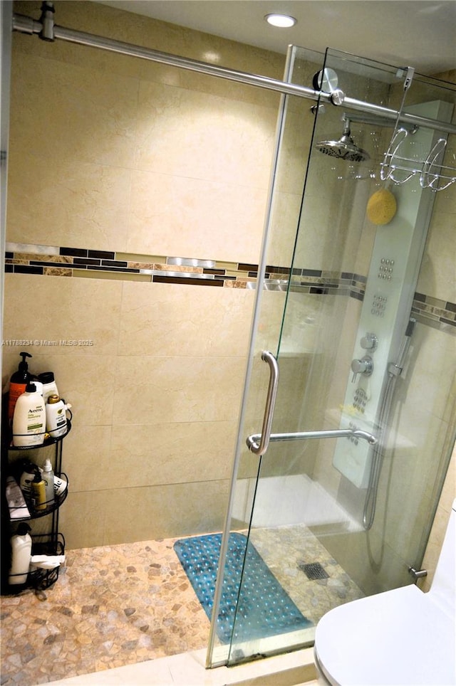 full bathroom with toilet, a shower stall, and recessed lighting