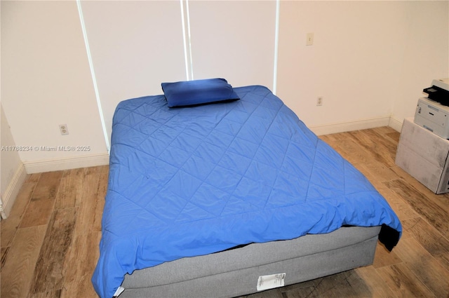bedroom featuring wood finished floors and baseboards
