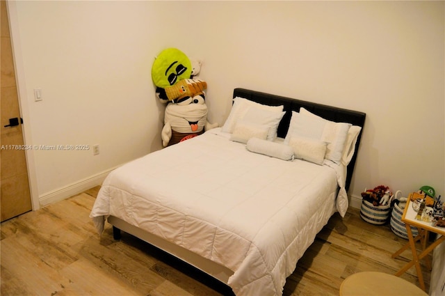 bedroom with baseboards and wood finished floors