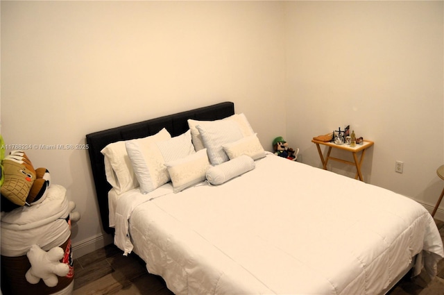 bedroom featuring dark wood-style flooring and baseboards
