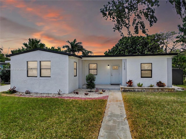 1550 NE 11th St, Homestead, FL 33033 - view of front of home with a porch, a lawn, and stucco siding