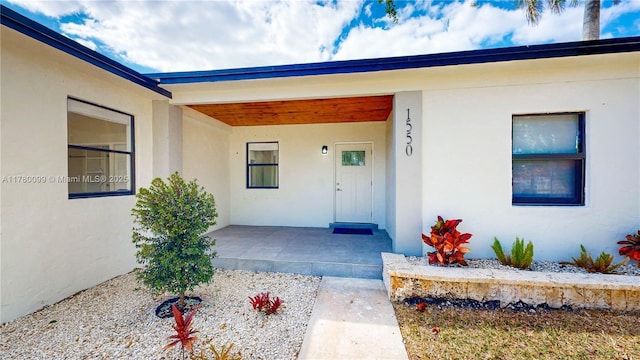 1550 NE 11th St, Homestead, FL 33033 - doorway to property with stucco siding and a porch