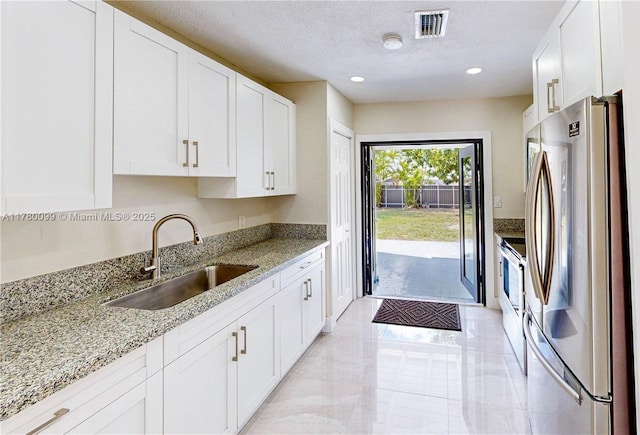 1550 NE 11th St, Homestead, FL 33033 - kitchen featuring freestanding refrigerator, a sink, electric stove, white cabinetry, and recessed lighting