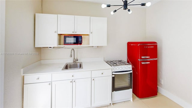 1550 NE 11th St, Homestead, FL 33033 - kitchen featuring white gas range oven, a sink, a chandelier, white cabinets, and refrigerator