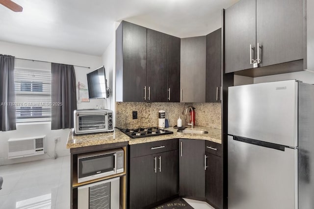 335 Ocean Dr Unit 310, Miami Beach, FL 33139 - kitchen with beverage cooler, stainless steel appliances, a sink, dark brown cabinetry, and decorative backsplash