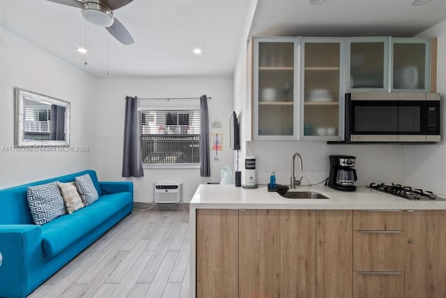 335 Ocean Dr Unit 122, Miami Beach, FL 33139 - kitchen with gas cooktop, a sink, stainless steel microwave, light countertops, and a wall mounted AC
