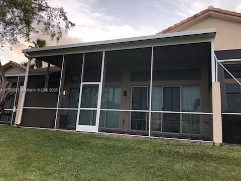 5134 W Madison Lakes Cir W, Davie, FL 33328 - back of property featuring stucco siding, a yard, and a sunroom