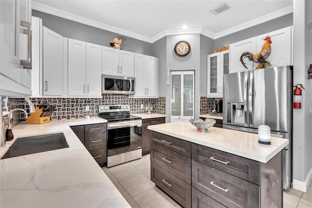 7738 NW 17th Pl, Pembroke Pines, FL 33024 - kitchen featuring appliances with stainless steel finishes, a sink, white cabinets, glass insert cabinets, and backsplash