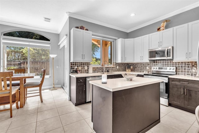 7738 NW 17th Pl, Pembroke Pines, FL 33024 - kitchen with stainless steel appliances, light countertops, a sink, tasteful backsplash, and crown molding